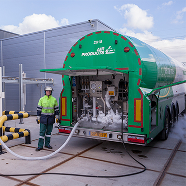 truck driver filling storage tank with industrial gas